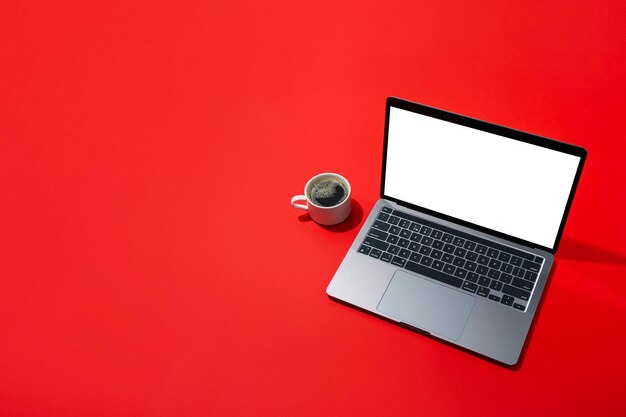 Koffie en laptop op rode achtergrondruimte voor tekst