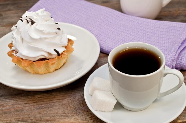 Koffie en taart op een houten tafel.