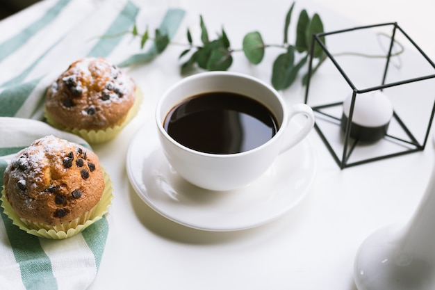 Koffie en twee muffins op witte ondergrond