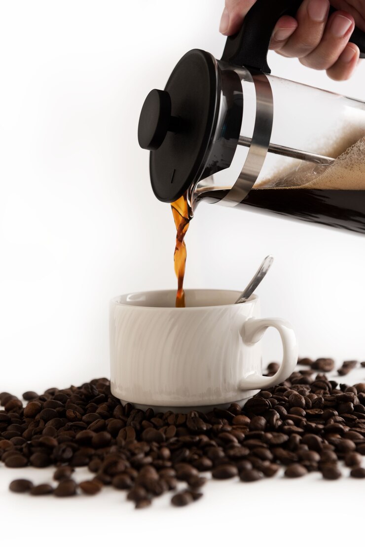 Foto koffie gieten op een witte koffiemok op koffiebonen achtergrond