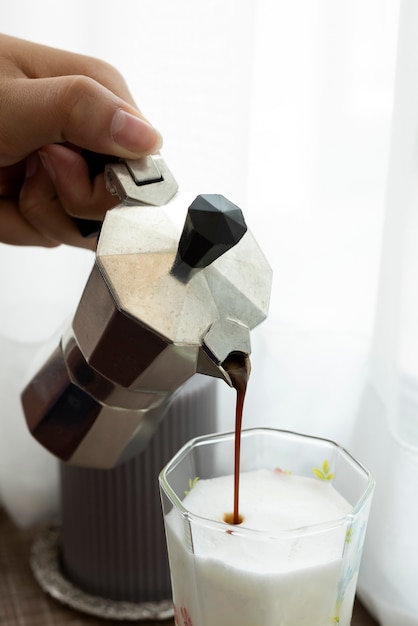 Koffie gieten van onechte pot in glas gaat melk