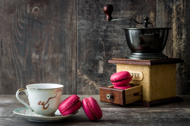 Koffie in de buurt van bitterkoekjes en molen op hout