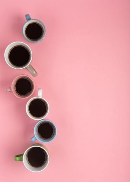 Koffie in de verschillende cups op de roze achtergrond. Flatlay, vrolijk dagconcept, verticale oriëntatie