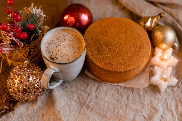 Koffie in een designmok en zelfgemaakte honingcake op een houten tafel in een gezellige kerstsfeer in een gezellige winter