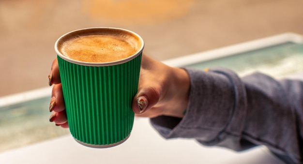 Koffie in een groene wegwerpbeker ter beschikking