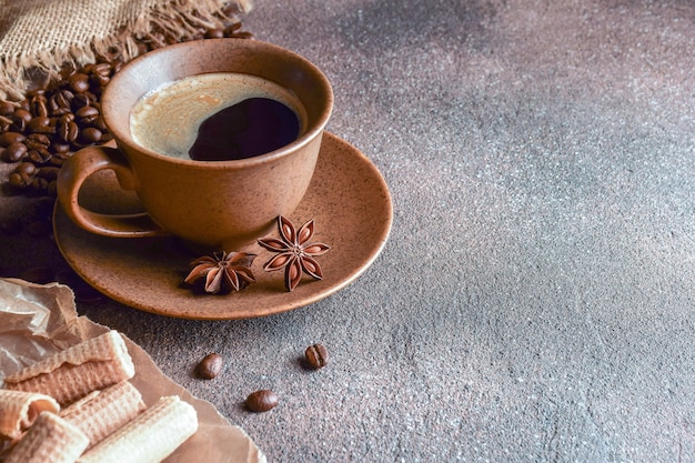 Koffie in een keramische beker met koffiebonen en koekjes op grijze achtergrond gray