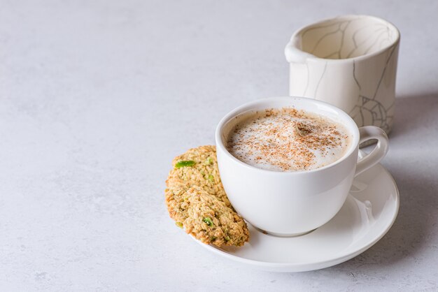 koffie in een mok met kaneel en melk