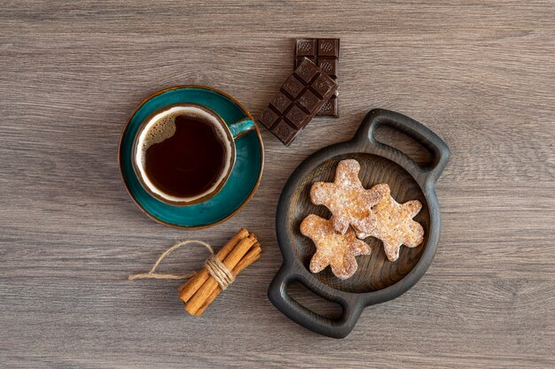 Koffie in een mooie ceramische kop chocolade kaneelkoekjes op een eiken plaat