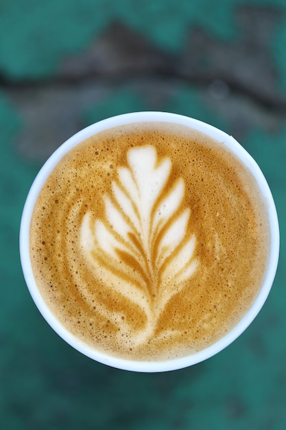 Koffie in een papieren beker op een houten tafel