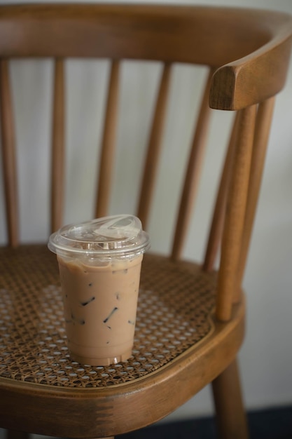 Koffie in een plastic beker op een andere vintage houten stoel in een café