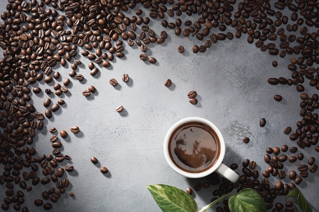 Koffie in een witte kop en koffiebonen op de tafel.