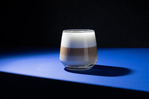 Koffie latte op een donkerblauwe achtergrond Gebruikte studioverlichting