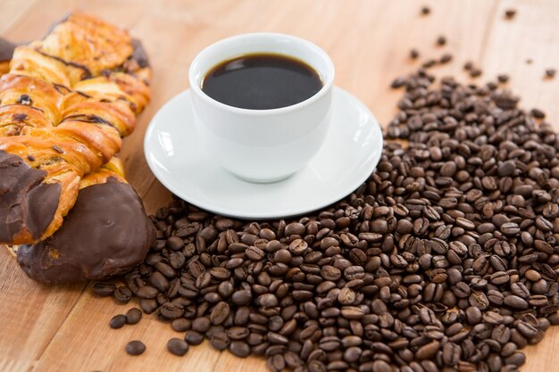 Koffie met gebrande koffiebonen en croissant