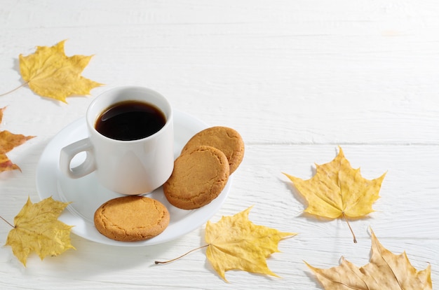 Koffie met havermoutkoekjes en gele herfstbladeren