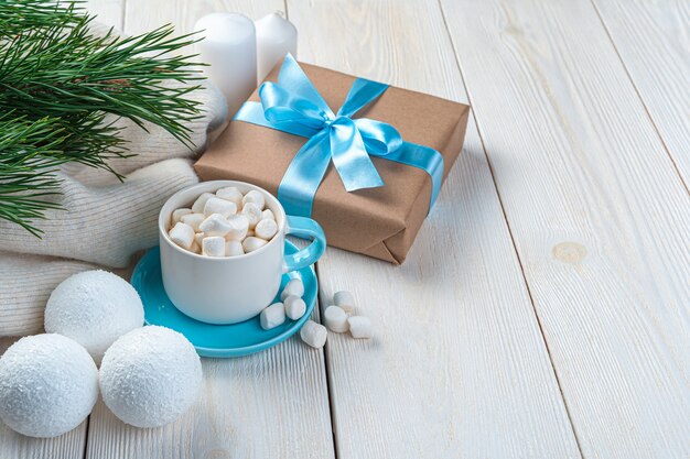 Koffie met marshmallows, dennentakken en kerstballen op een lichte achtergrond met ruimte om te kopiëren