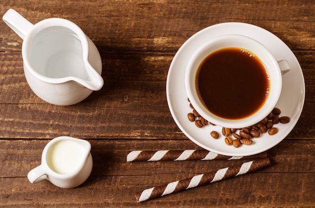 Koffie met melk en wafeltjebroodjes op een houten achtergrond