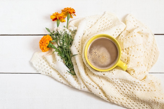 Koffie met melk gebreide sjaal en bloemen tagetes