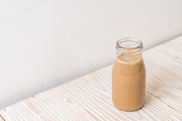 koffie met melk in fles op houten oppervlak