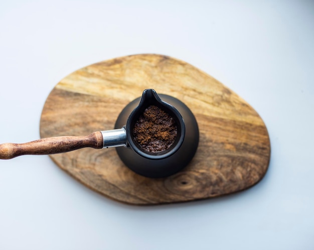 Koffie met schuim gebrouwen in een keramische Turk close-up op een houten tafel