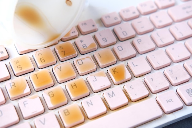 Koffie morsen op laptop toetsenbord close-up