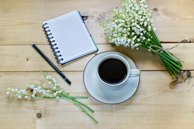 Koffie op een houten achtergrond en bloemen.