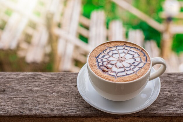 Koffie op een houten tafel op een natuurlijke achtergrond in een warme kleurentuin