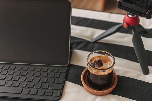 Koffie op het bureau van de maker van de inhoud met statiefcamera en laptop