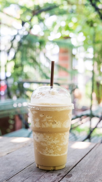 Koffie smoothie op een houten tafel en plant achtergrond.