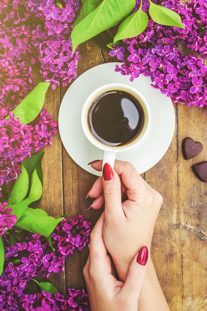 Koffie voor ontbijt en lila bloemen. Selectieve aandacht.