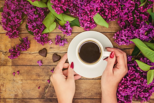 Koffie voor ontbijt en lila bloemen. Selectieve aandacht.