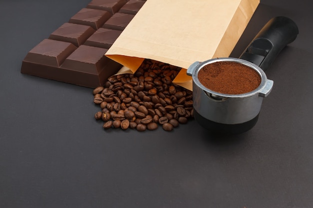 Koffieachtergrond - espresso in een houder, koffiebonen en een reep chocolade