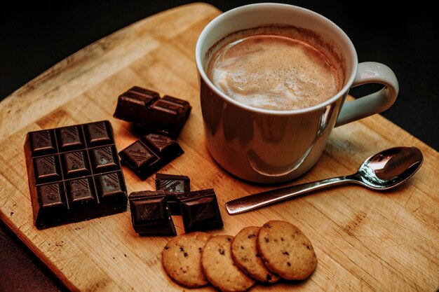 Foto koffiebeker en koekjes op tafel.