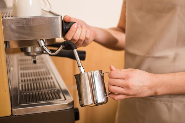 Koffiebereiding. Close-up van een kopje dat wordt gebruikt voor de bereiding van koffie door een aardige positieve aangename vrouw