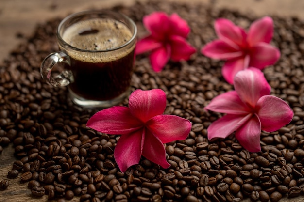 Koffiebonen en bloemen op een tafel met een kopje koffie
