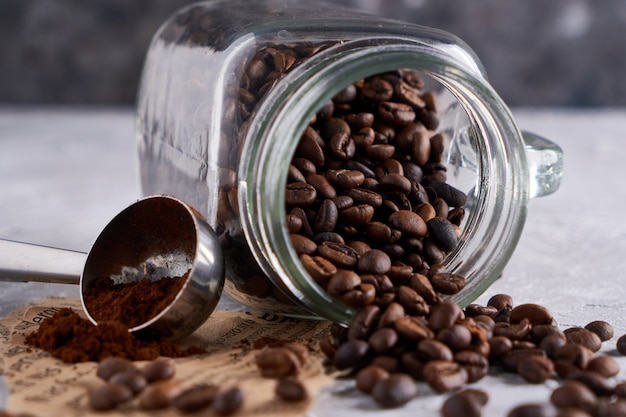 Koffiebonen in een glazen pot op een grijze tafel