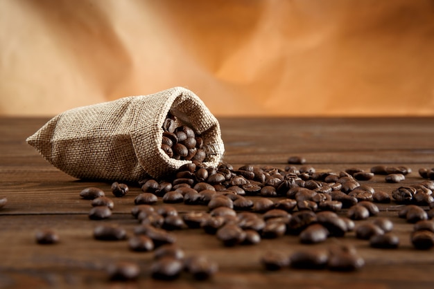 Koffiebonen in een kleine zak op een houten tafel