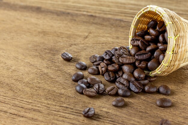 Koffiebonen in kleine bamboemand op houten tafel