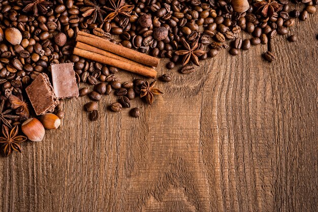 Koffiebonen kaneel steranijs chocolade hazelnoten op een houten tafel