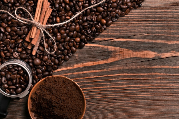 Koffiebonen, kaneelstokjes en gemalen koffie op rustieke houten tafel, van bovenaf bekijken met ruimte voor tekst. Stilleven. Mock-up. plat leggen