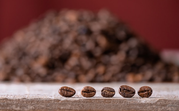 Koffiebonen op de voorgrond op een houten bord, in de berg van koffiebonen