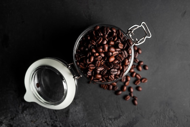 Koffiebonen op donkere achtergrond. Koffiebonen in glazen pot. Hoge kwaliteit foto