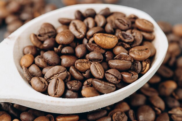 Koffiebonen op houten lepel geïsoleerd op donkere achtergrond