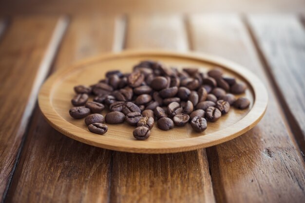 koffiebonen op houten schotel op tafel