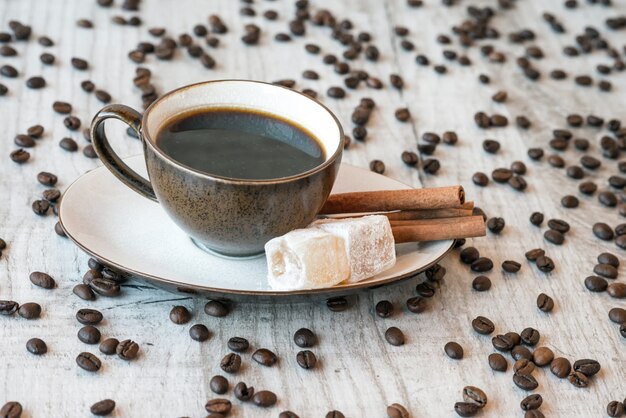 Koffiebonen op houten tafel met snoep en croissant