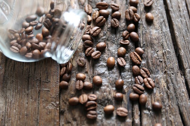 Koffiebonen staan op de houten getextureerde tafel met de glazen pot