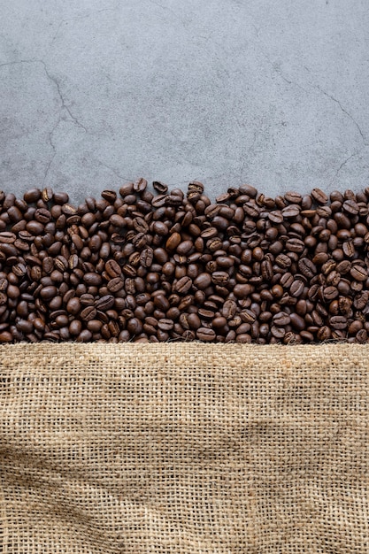 Koffieboon en zak op oude cementachtergrond