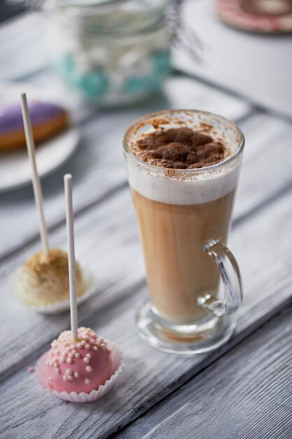 Koffiecappuccino met mooie snoepjes op houten achtergrond Mooie snoepjes