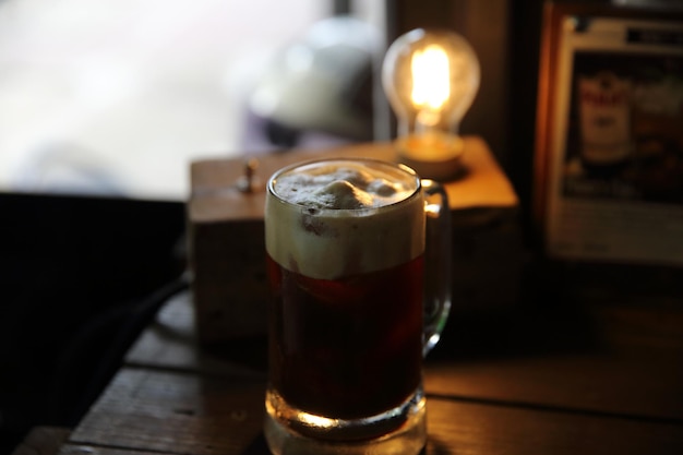 Koffiecocktail met koffieboon en rozemarijn bovenop met houten achtergrond