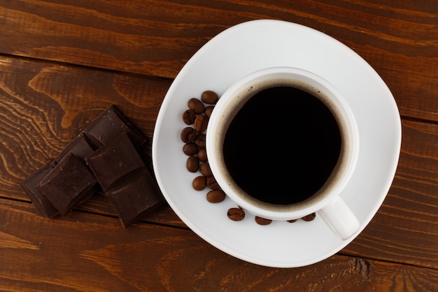 Koffiedrank en chocolade in een witte kop op een houten oppervlak