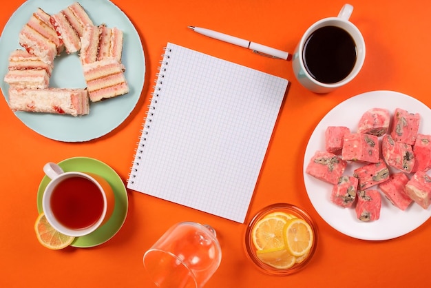 Koffiedrank en zoet eten op een oranje achtergrond Eten en drinken